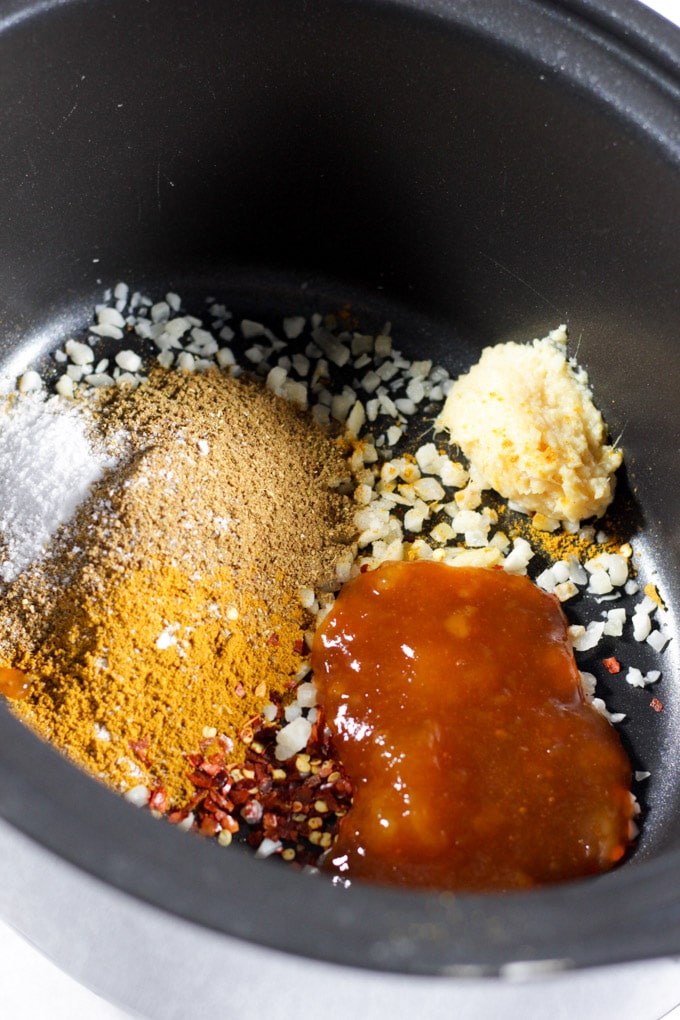 Spices and mango chutney and garlic and ginger in a slow cooker