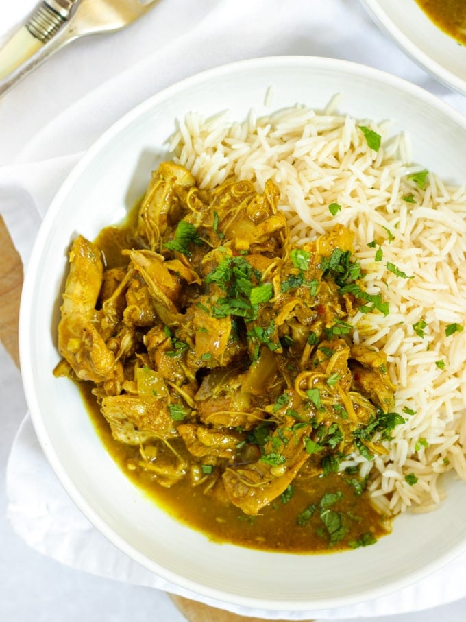 Easy slow cooker chicken curry in bowls with rice sprinkled with mint