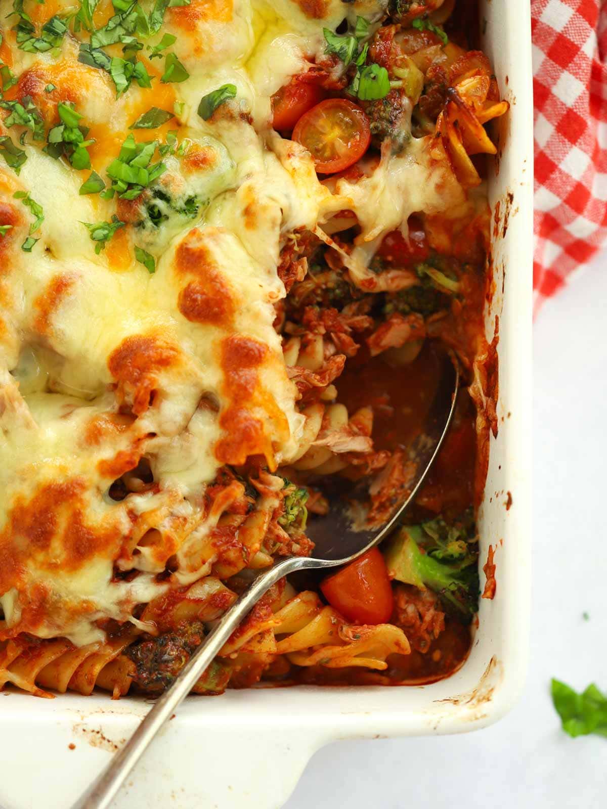 A spoon in a dish of Tuna Pasta Bake fresh out of the oven, ready to serve up.