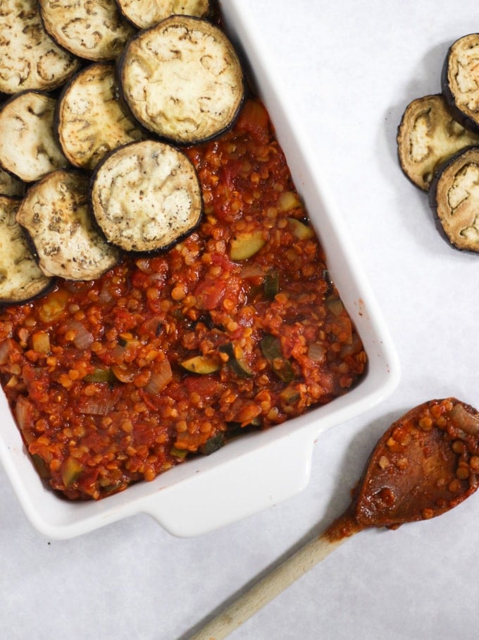 Aubergine slices on top of lentil rags in a white casserole dish