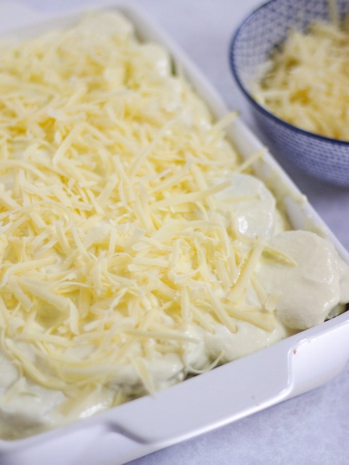 Cheese topped potatoes in a casserole dish. How to make Vegetarian Moussaka, step 6.