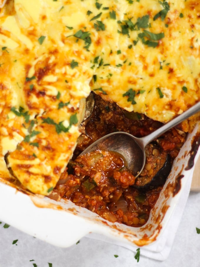 Vegetarian Moussaka sprinkled with herbs with lentil ragu and aubergines and ricotta topping
