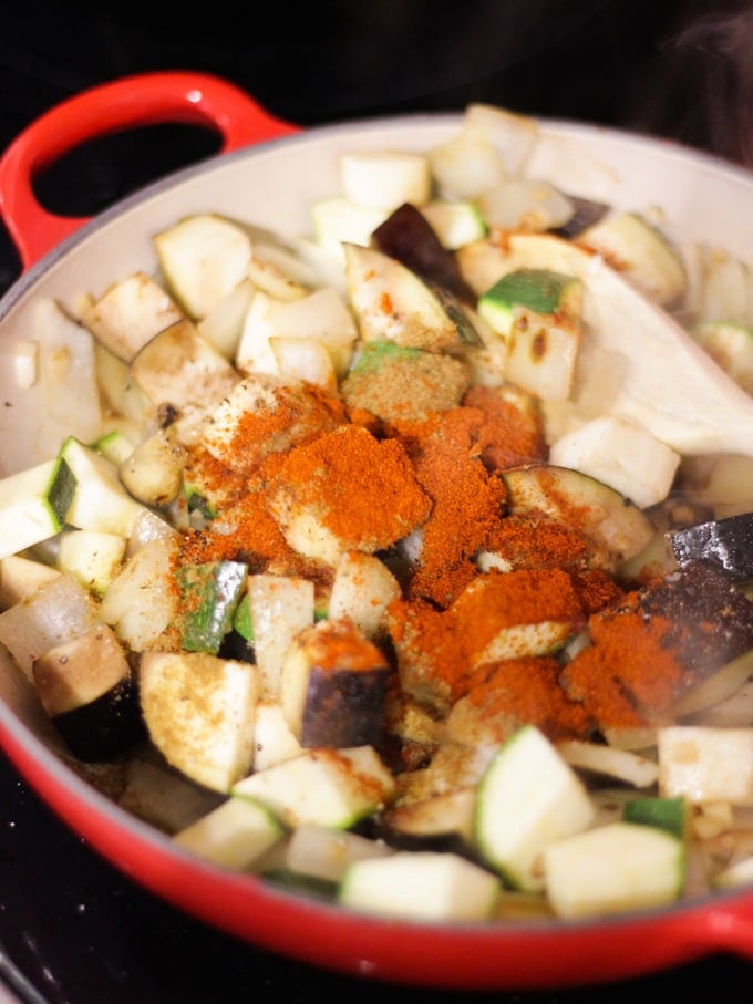 Chopped vgetables and spices in a pan, ready to cook Mediterranean Halloumi Bake.