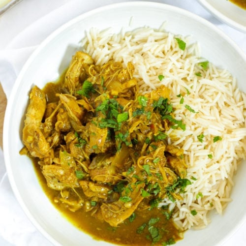 Easy slow cooker chicken curry in bowls with rice sprinkled with mint