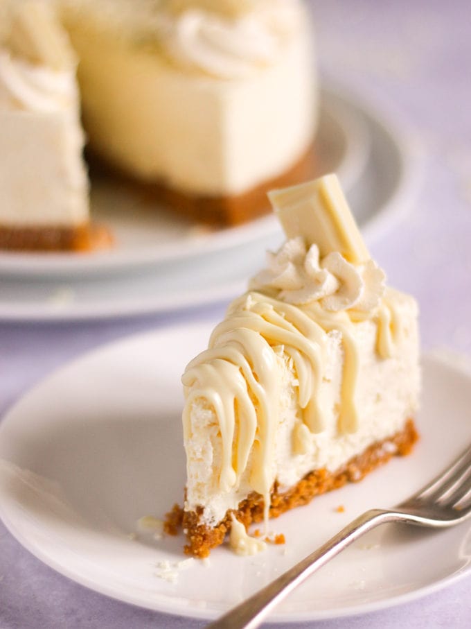 Slice of white chocolate cheesecake on a plate with fork.