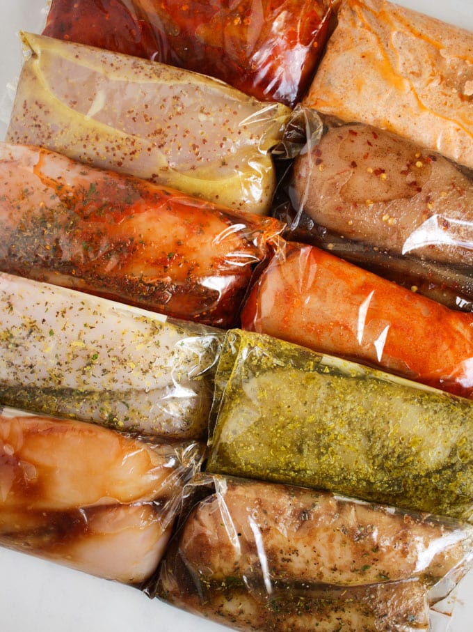 Chicken breasts in different marinades in plastic bags