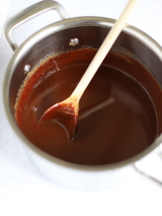 Saucepan of melted chocolate mixture with wooden spoon