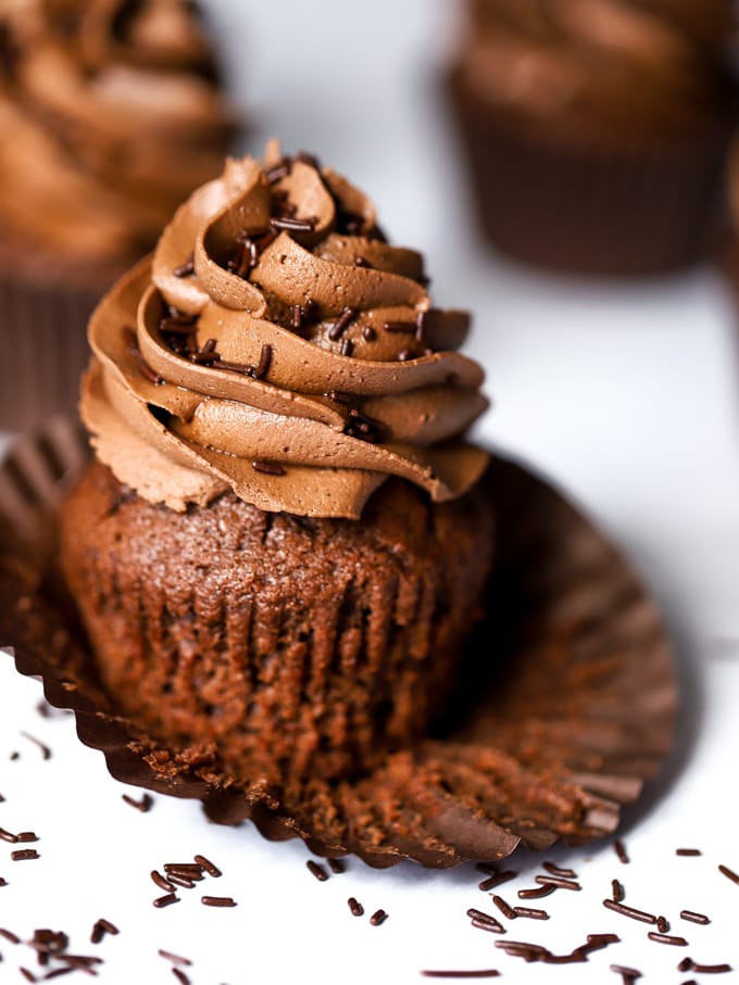 Easy Chocolate cupcakes recipe with open case and swirl of basic milk chocolate icing