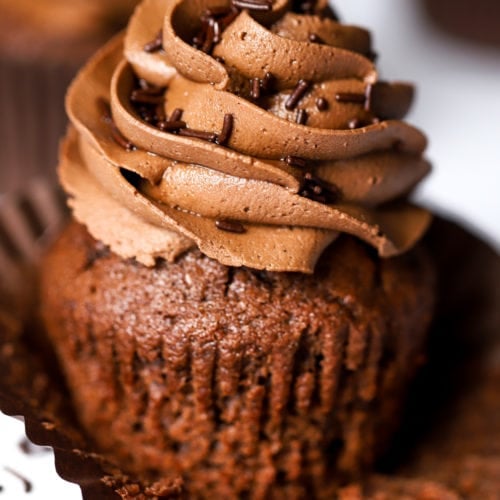 Quick and easy chocolate cupcake with chocolate buttercream icing swirl on top and sprinkles.