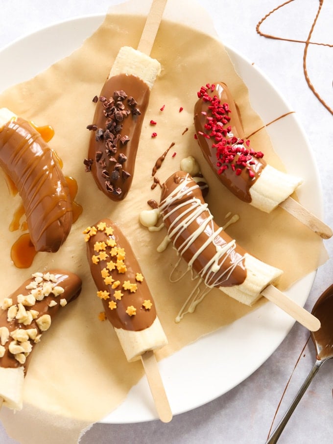 Bananas ready to be frozen, dipped in chocolate with sprinkles