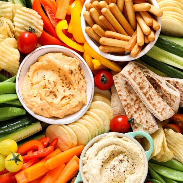 Hummus platter with breadsticks, dips, crisps, cucumber, tomatoes, carrots and crisps