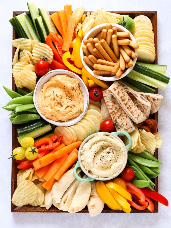 Hummus platter with dips and vegetables, including cucumber and peppers for kids