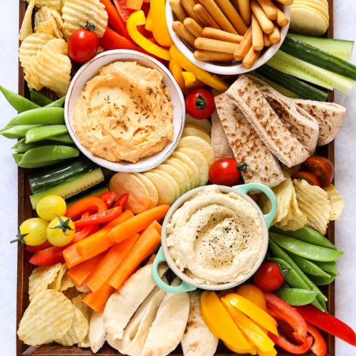 Hummus platter with dips and vegetables, including cucumber and peppers for kids
