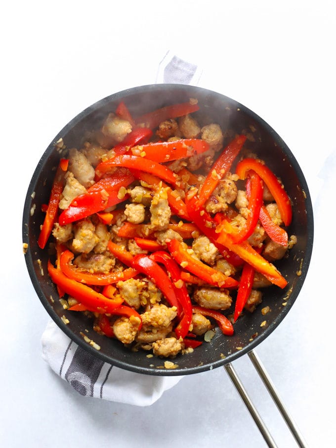 Peppers, sausage and onions frying in a frying pan for the recipe Sausage Pasta.