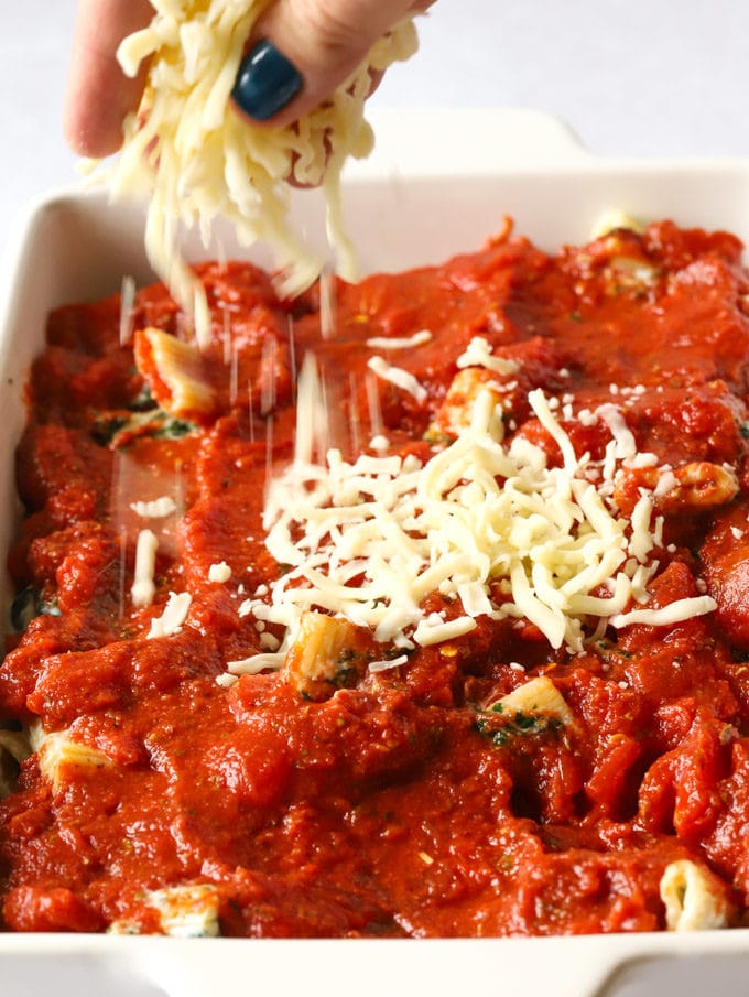 Tomato sauce spread in a dish ready to be topped with mozzarella cheese.
