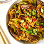 Beef Stirfry with green peppers, spring onions and chopsticks
