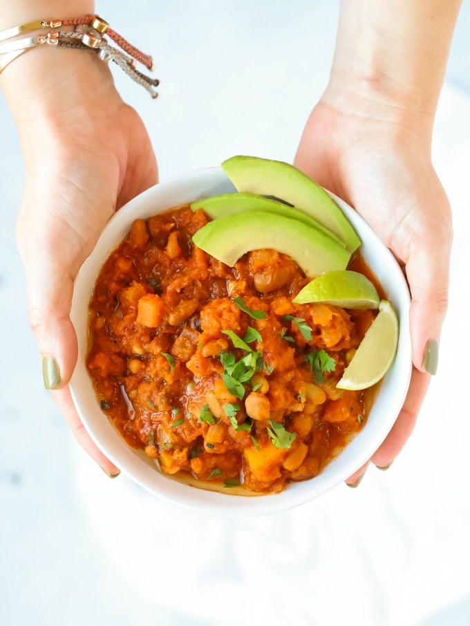 Vegetarian chilli in a bowl with chipotle and butternut squash, avocado and lime