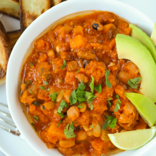 Vegetarian chilli made with butternut squash and chipotle served with potato wedges, avocado and lime