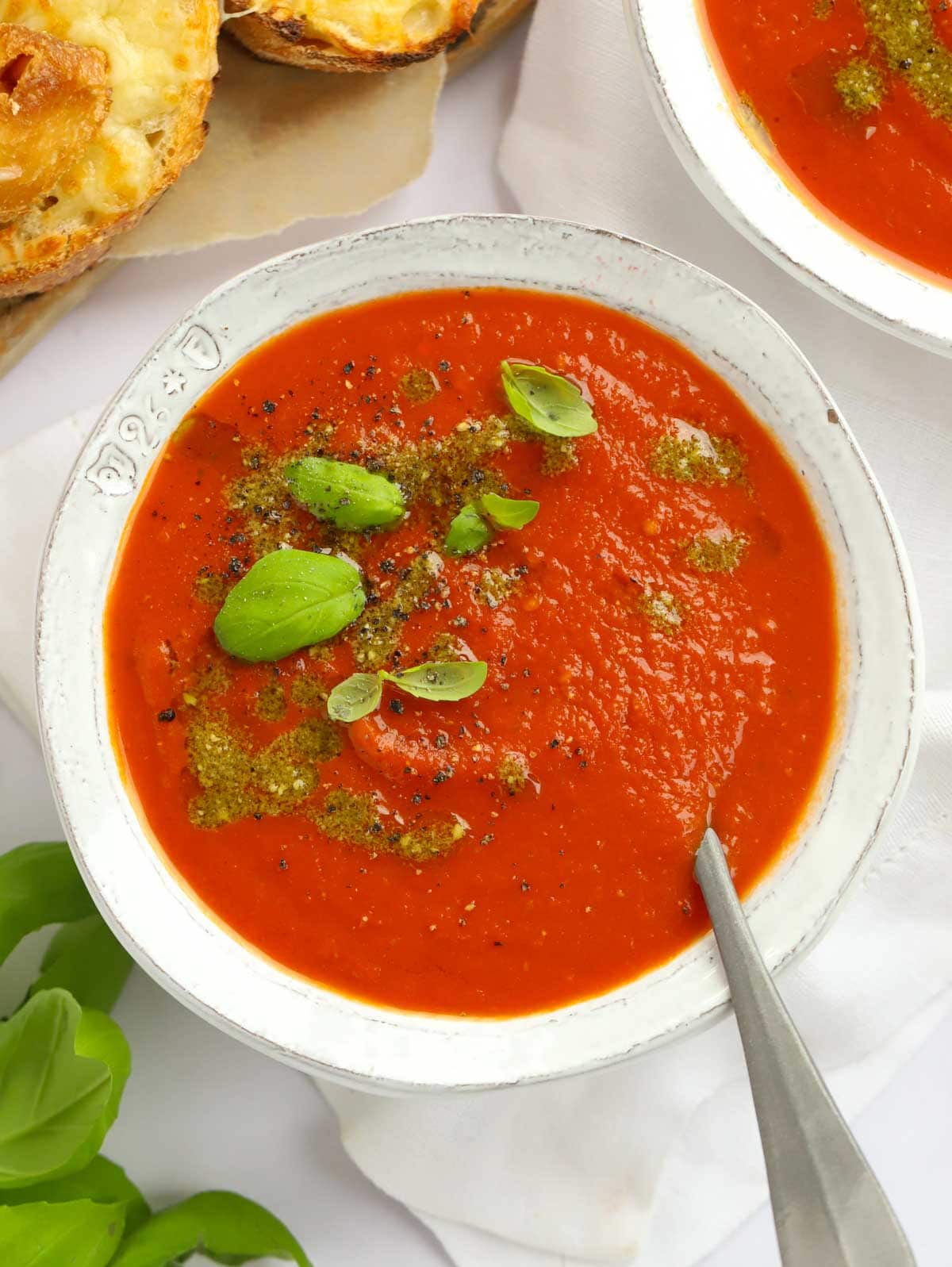 Easy Tomato Soup recipe ready in 20 minutes and garnished with pesto.