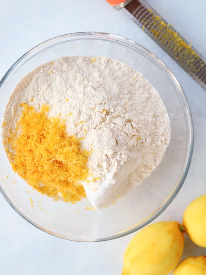 Flour and lemon zest in a bowl for Lemon Drizzle Cake ingredients.