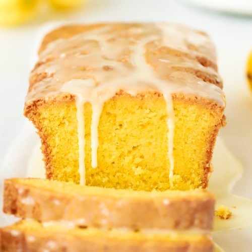 Lemon drizzle cake loaf recipe with runny icing, sliced and ready to eat.