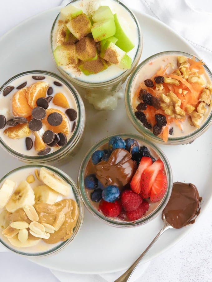 Easy healthy overnight oats recipe with various toppings in jars, looking from above.