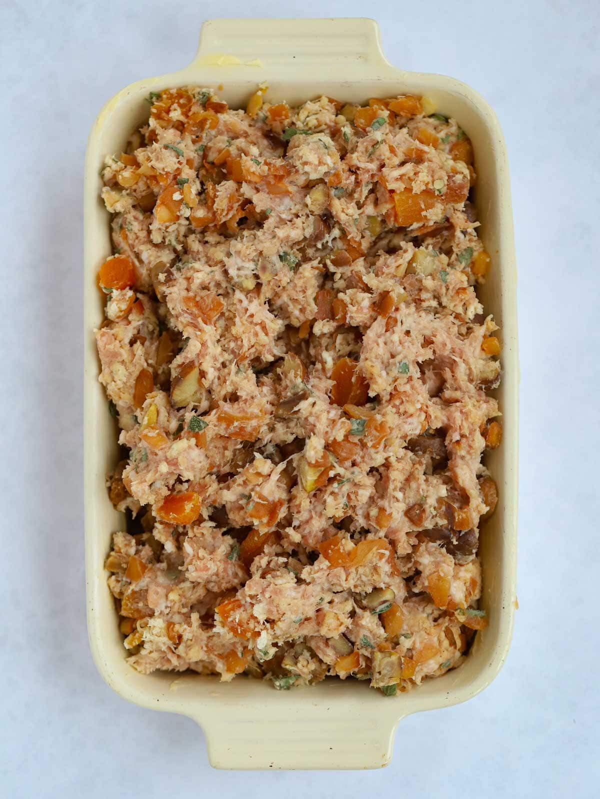 Uncooked sausage meat with apricots for a stuffing recipe.