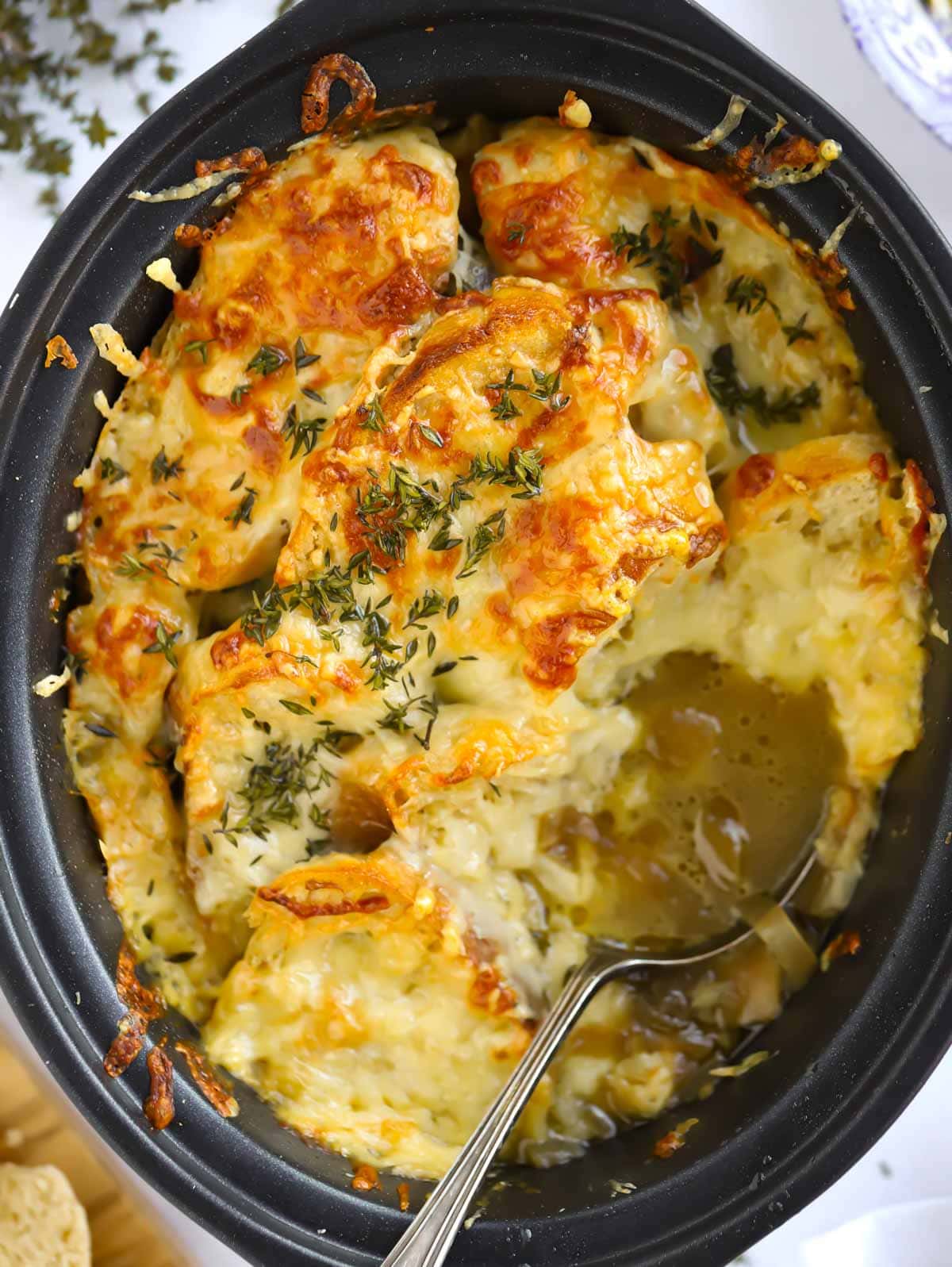 close up shot of French onion soup with crispy cheese crust in slow cooker