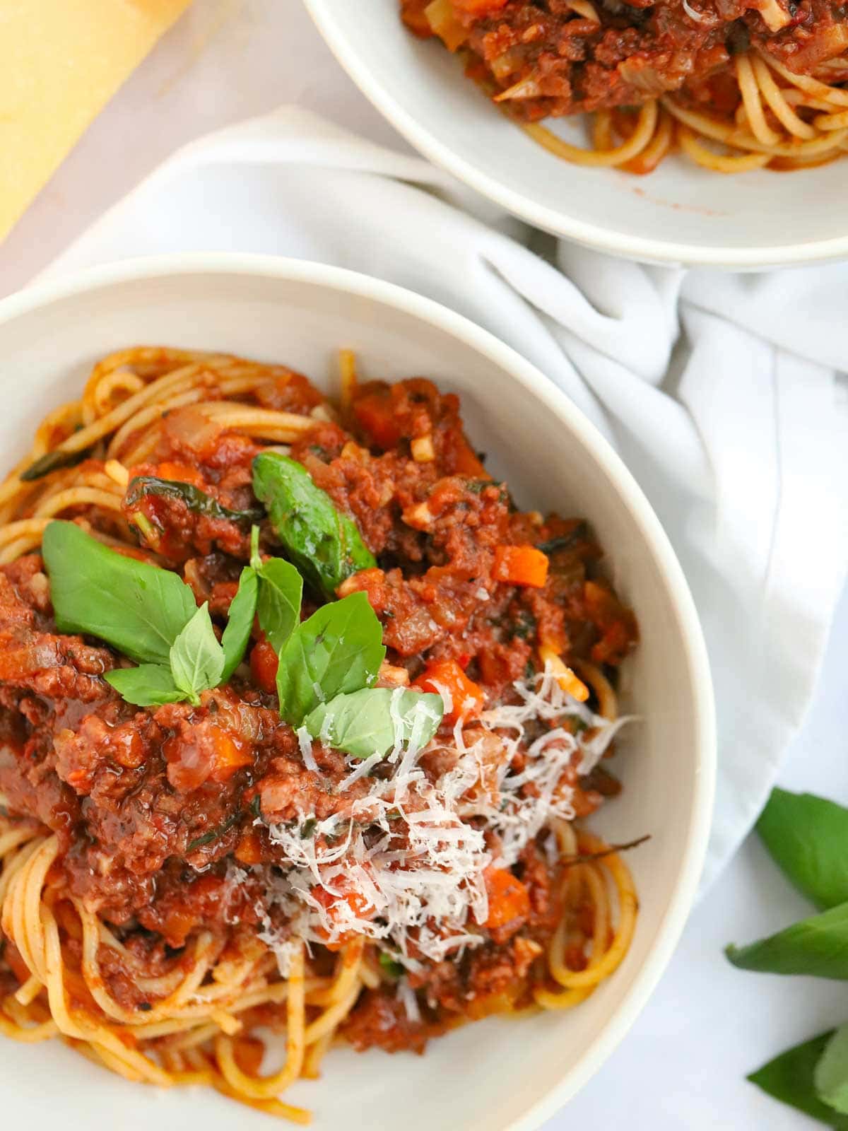 slow cooked beef bolognese on spaghetti in bowls