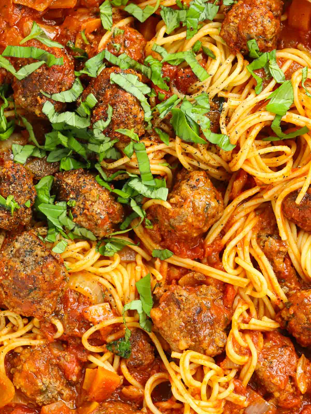 close up of homemade meatballs made from scratch mixed with sauce and spaghetti