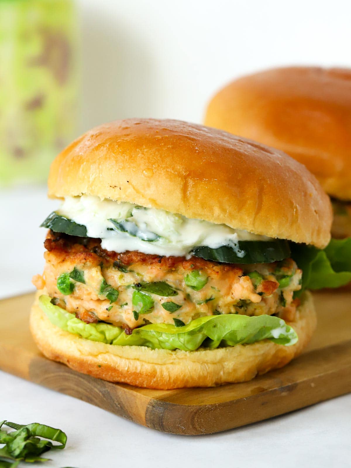 Side view of a Salmon Burger in a bap with salad