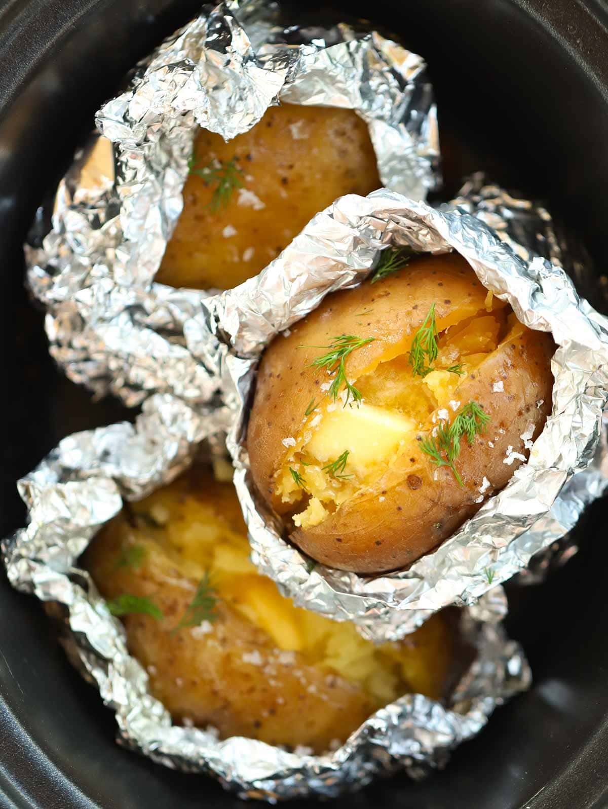 Jacket potatoes cooked in foil in the slow cooker for eight hours.