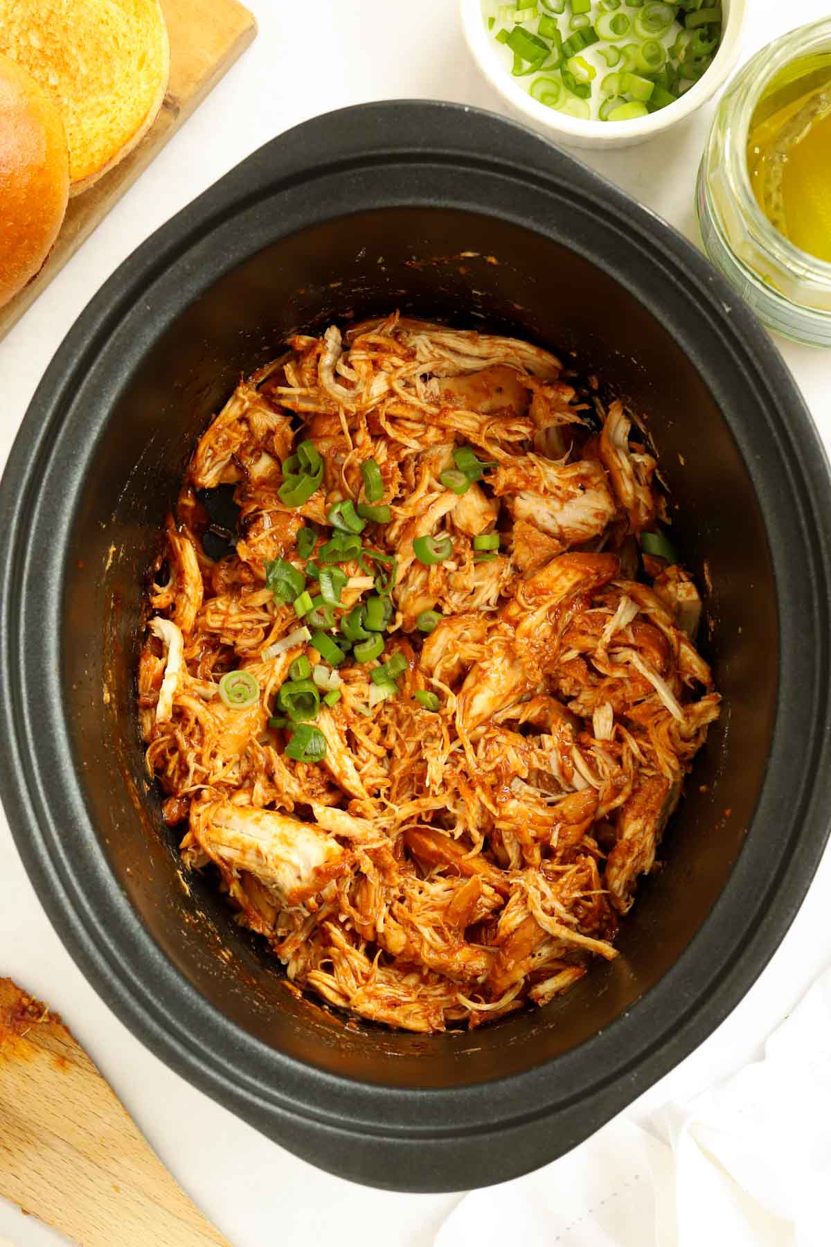 Barbecue Pulled Chicken Slow Cooker Recipe topped with spring onions.