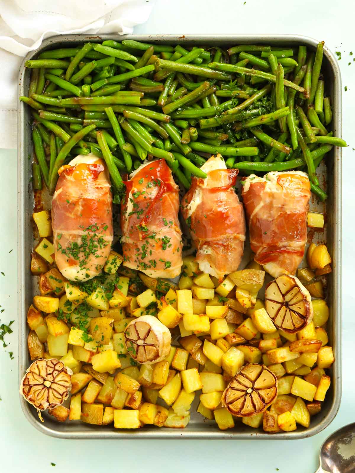 Recipe for bacon wrapped chicken served with potatoes and green beans