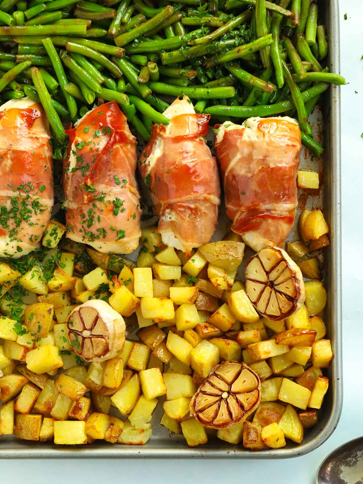 Tray with meal for four of bacon wrapped chicken with green beans and cubed potatoes