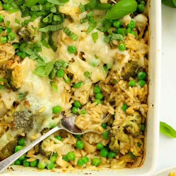 A dish with broccoli, orzo and peas, topped with melted cheese