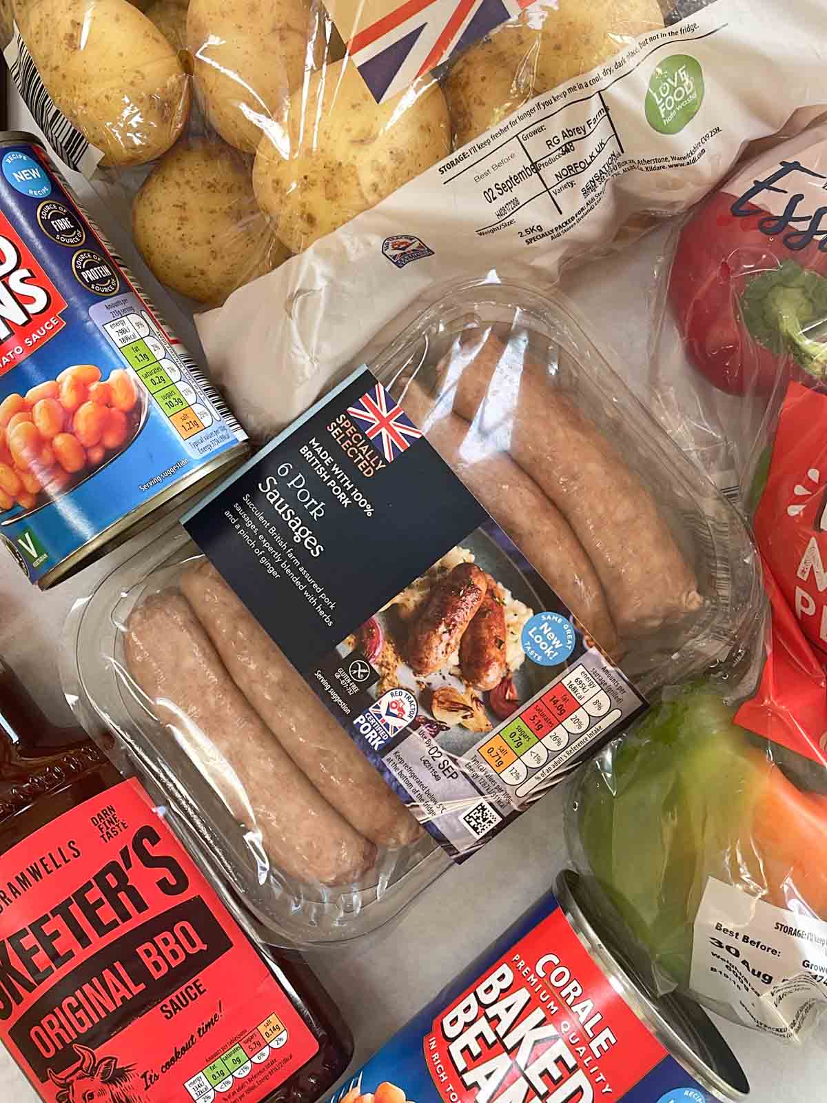 Raw ingredients for Cowboy Pie, including potatoes, sausages and beans.