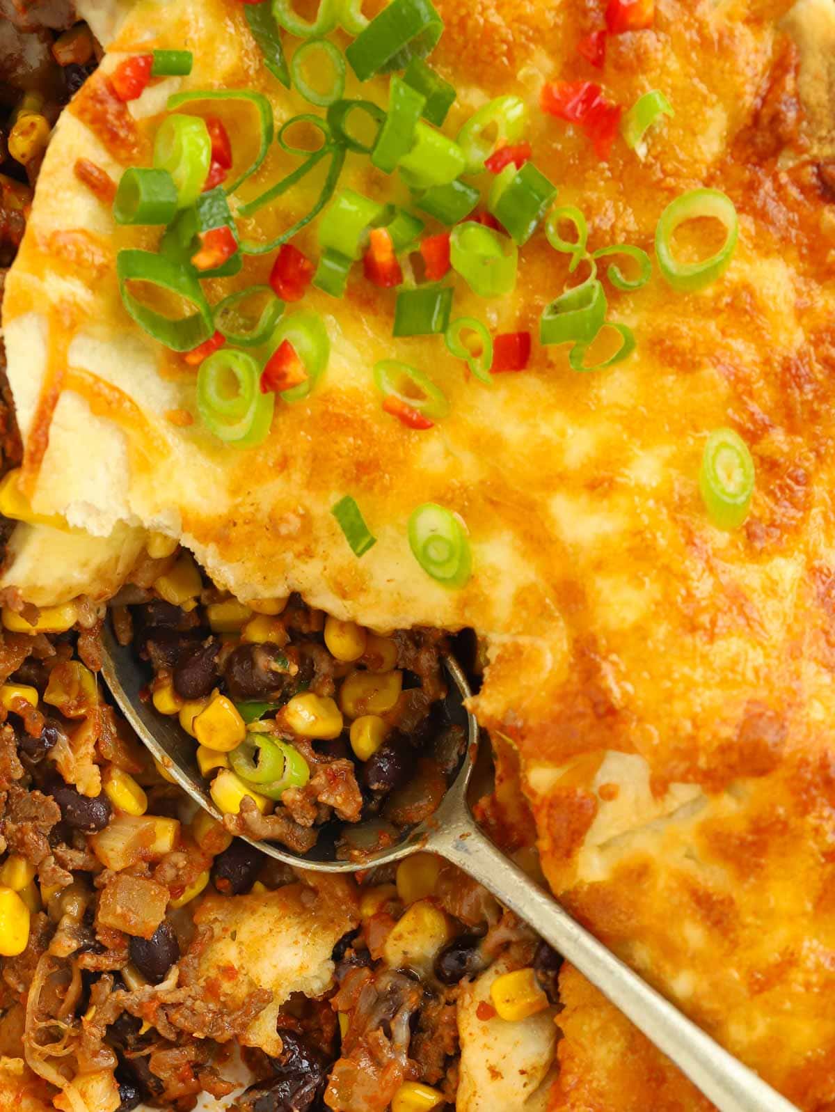 Close up of Mexican Lasagne with a spoon scooping out a portion.