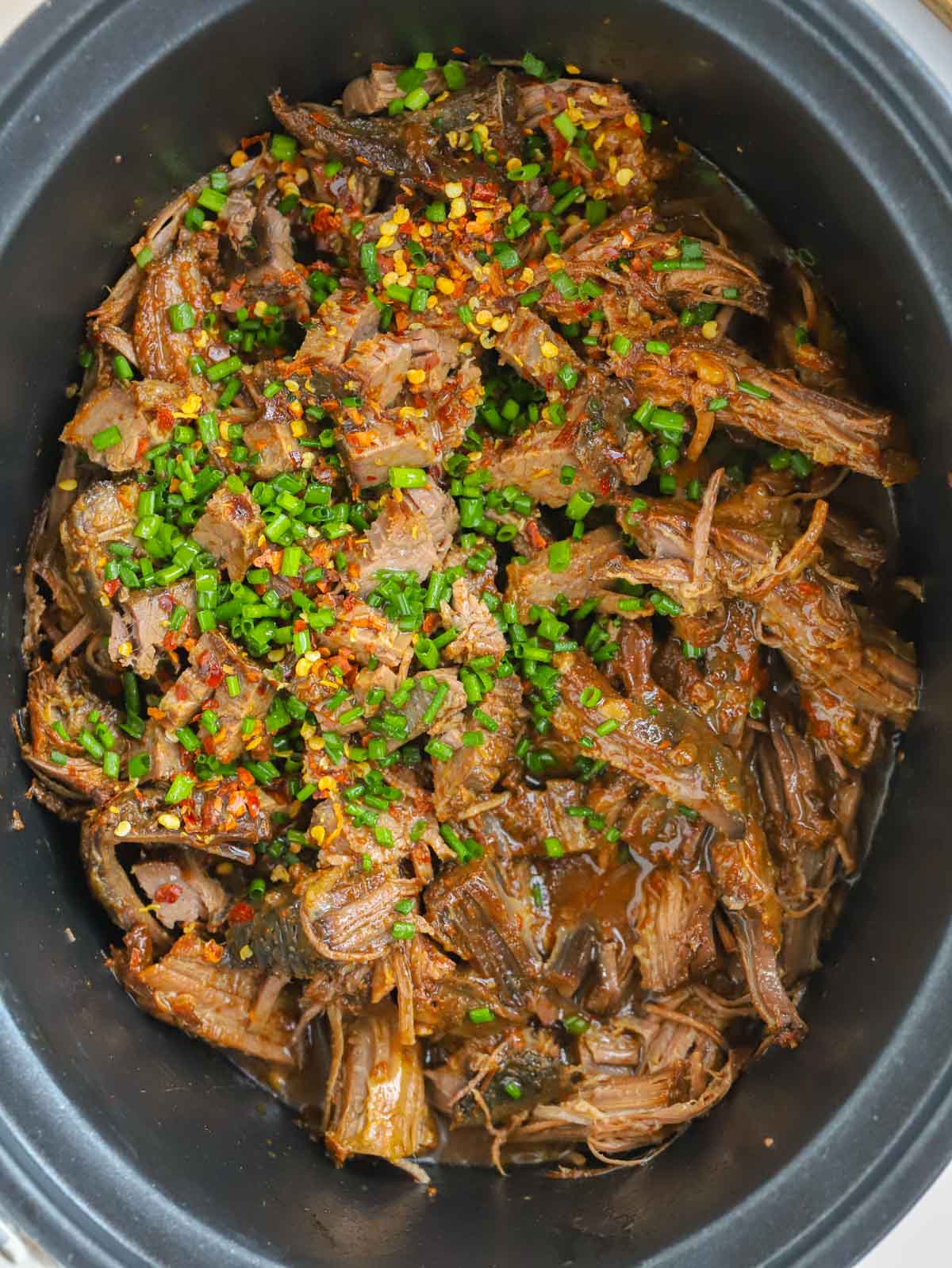 Close up of slow cooker beef brisket in a pan.
