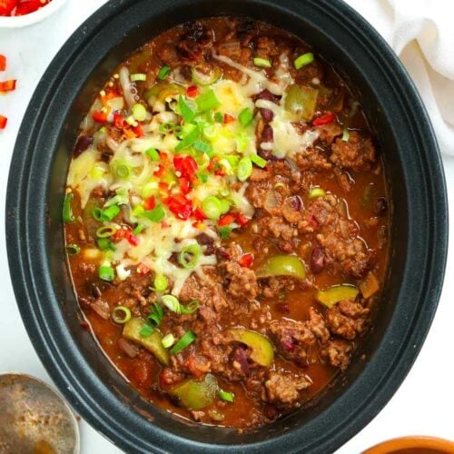 Slow cooker Chilli Con Carne topped with cheese and chillis after it has finished cooking.