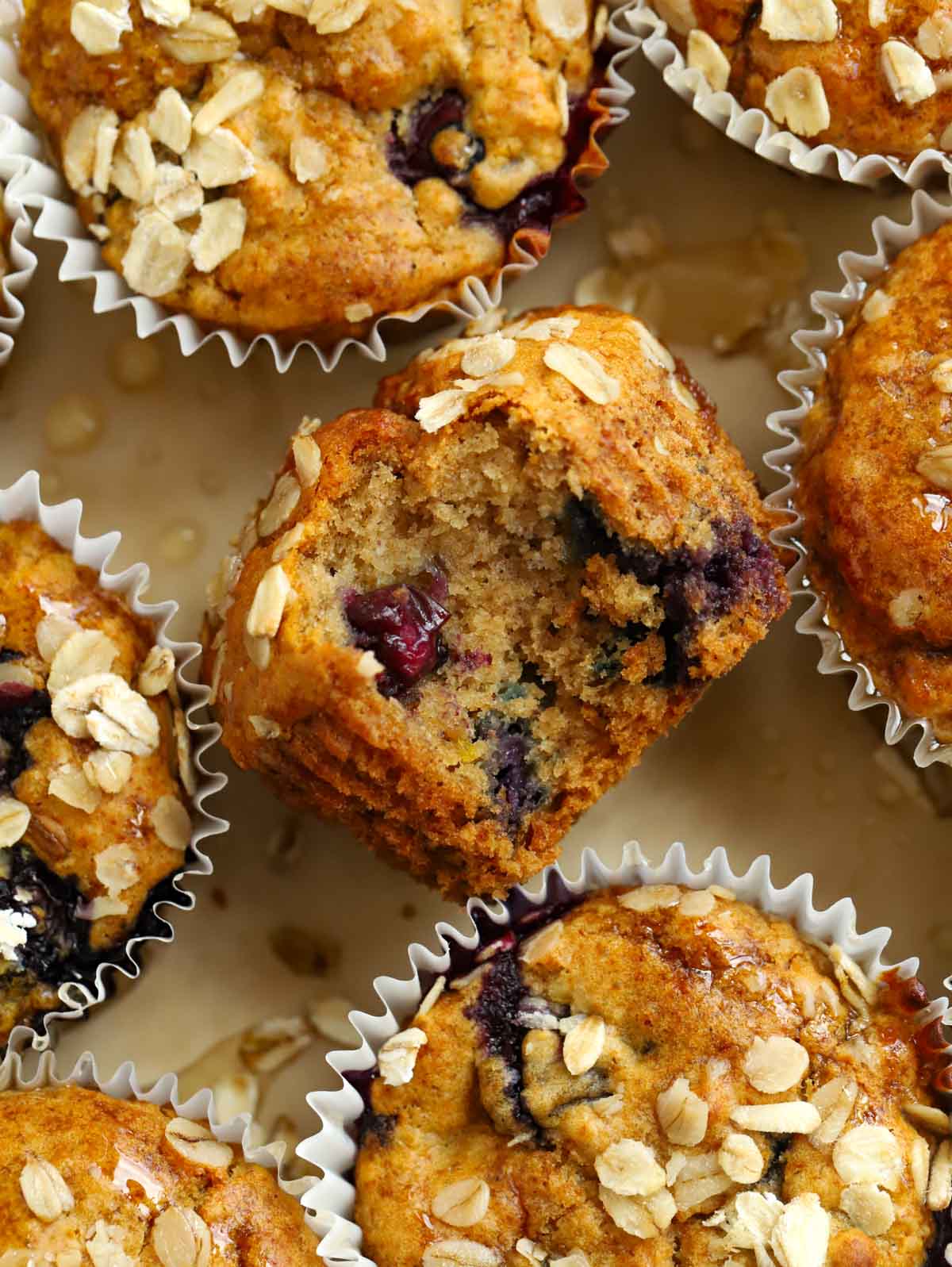 Close up of a healthy breakfast muffin on a tray of other muffins with a blueberry filling.