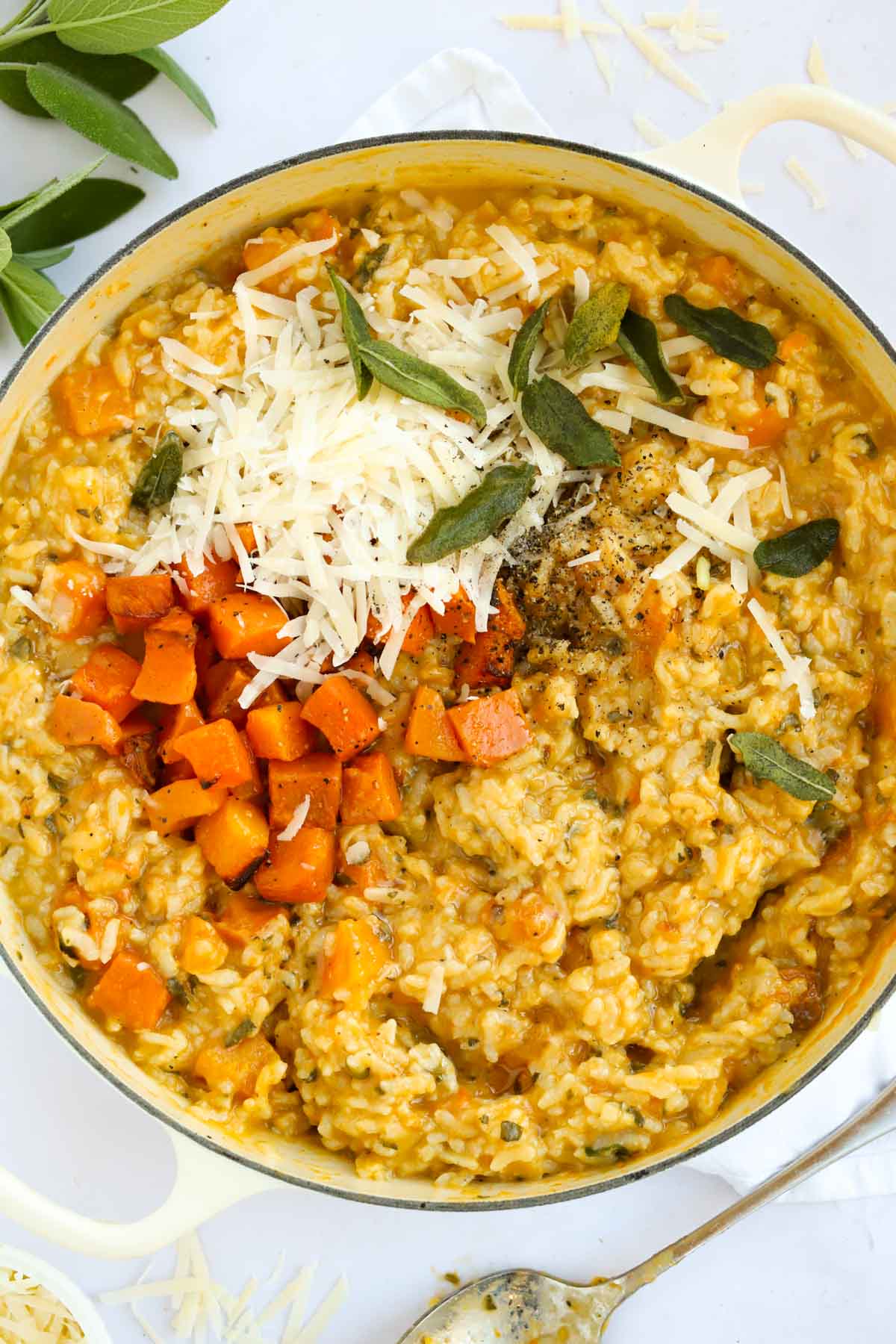 Large pot of butternut squash risotto topped with sage and cheese.