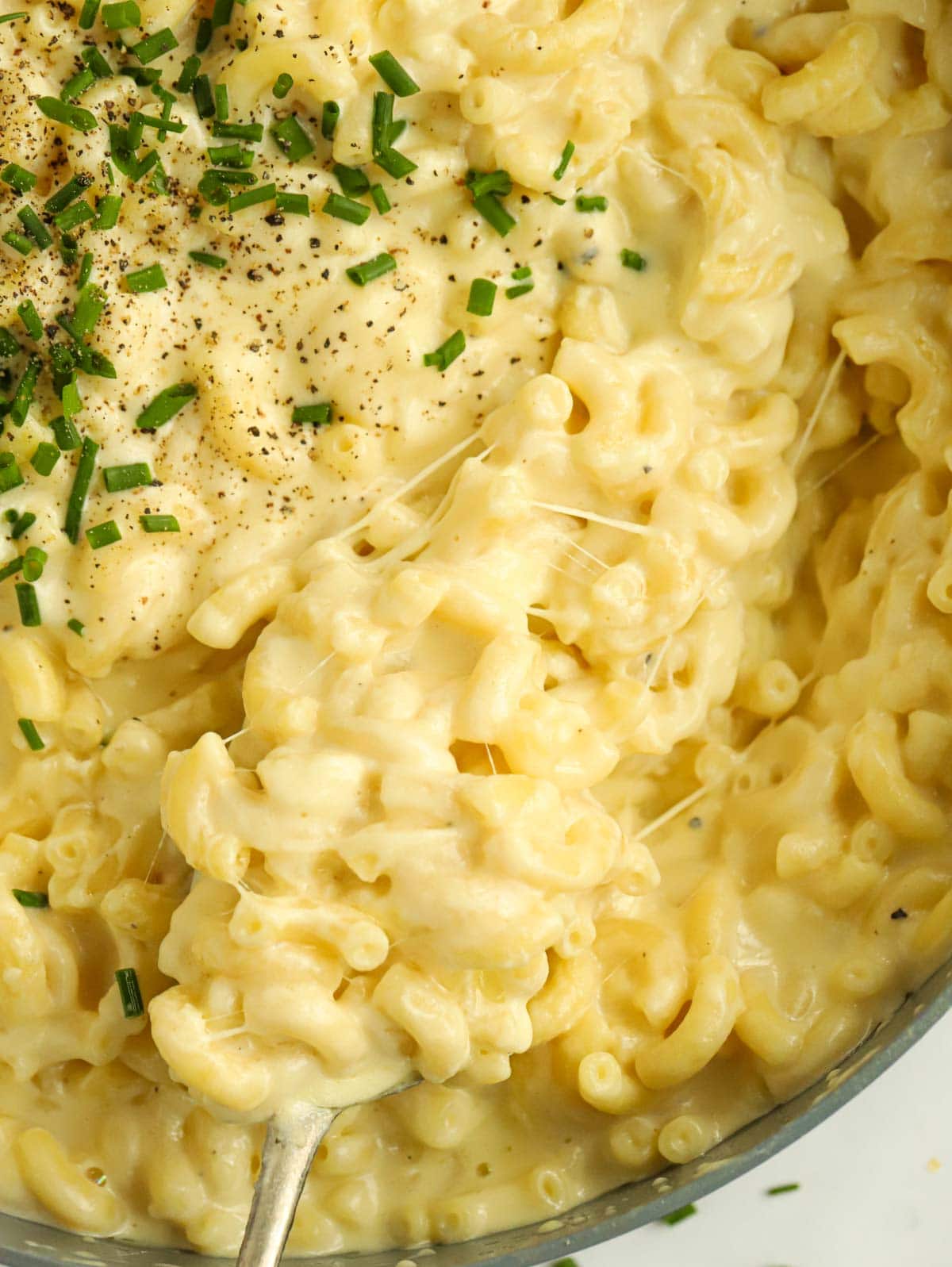 Close up of a pan of simple Macaroni Cheese with cheesy pull.
