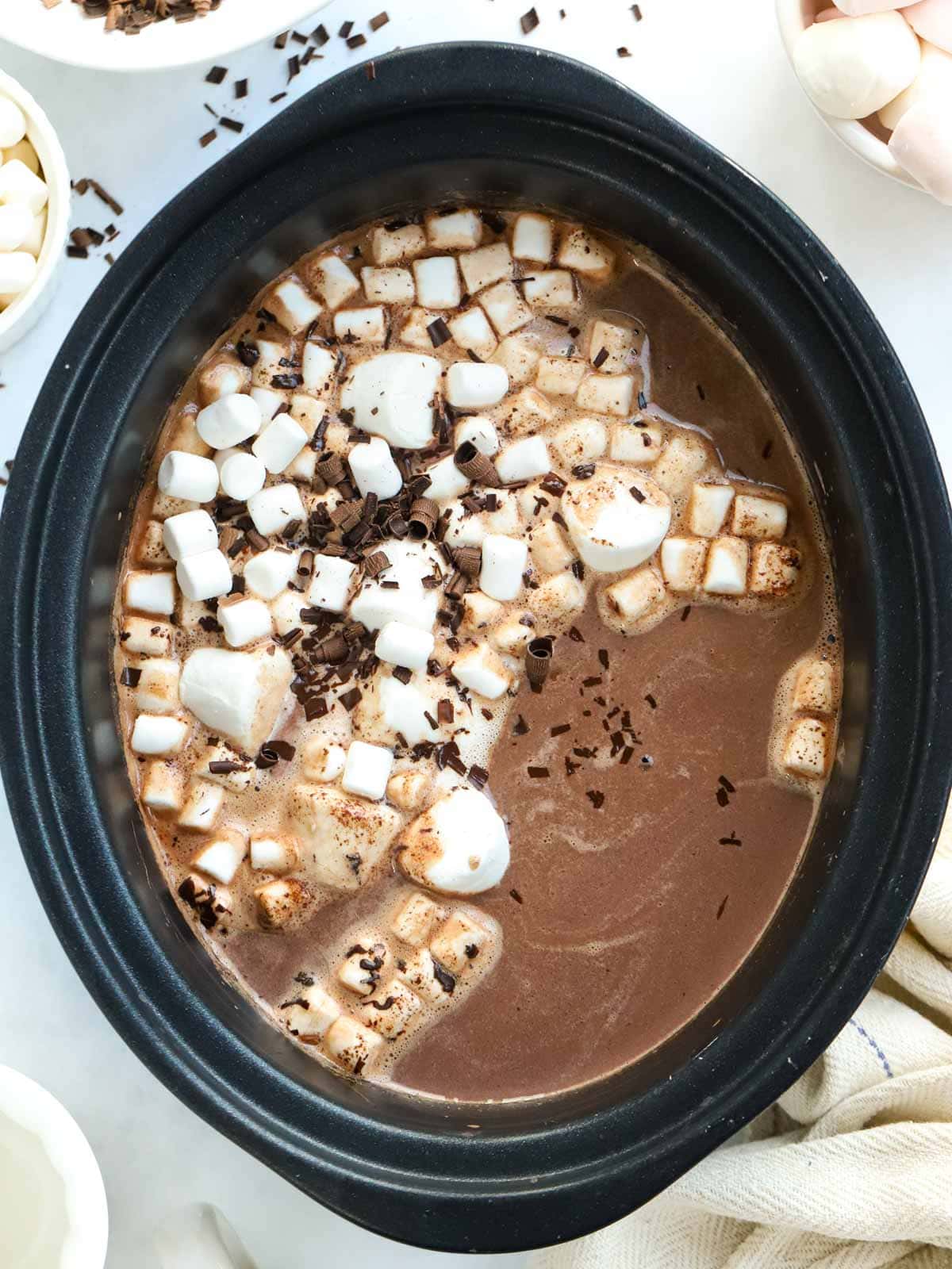 Slow Cooker Hot Chocolate topped with marshmallows and chocolate sprinkles.