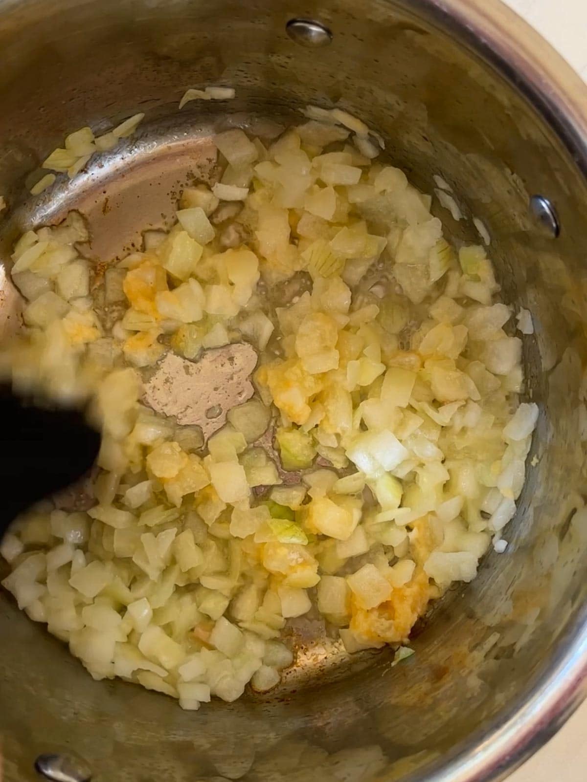 Frying onions and garlic in a saucepan to soften.