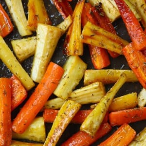 Close up of honey roasted carrots and parsnips on a baking tray, out of the oven.