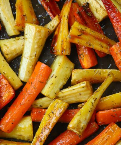 Close up of honey roasted carrots and parsnips on a baking tray, out of the oven.