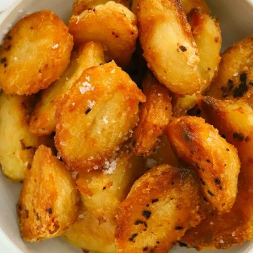 A bowl of golden roast potatoes out of the oven.