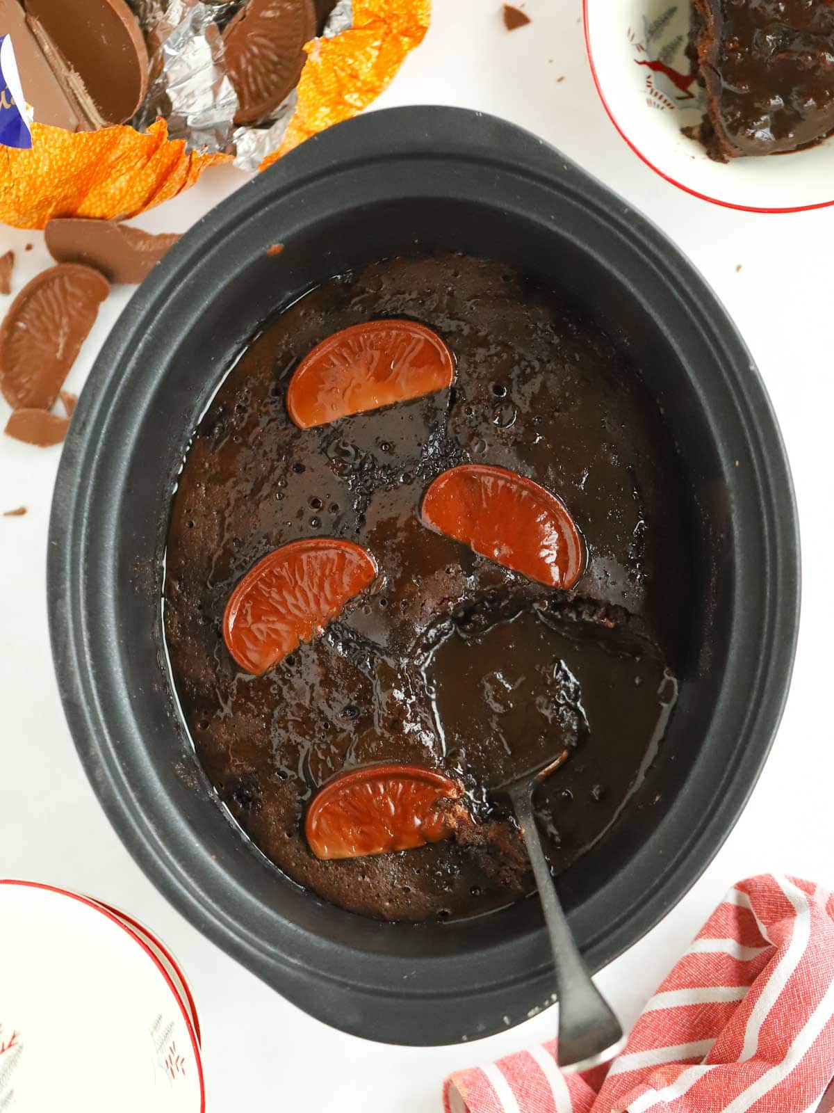 Slow cooker chocolate pudding with chocolate oranges, serving straight out of the pan.