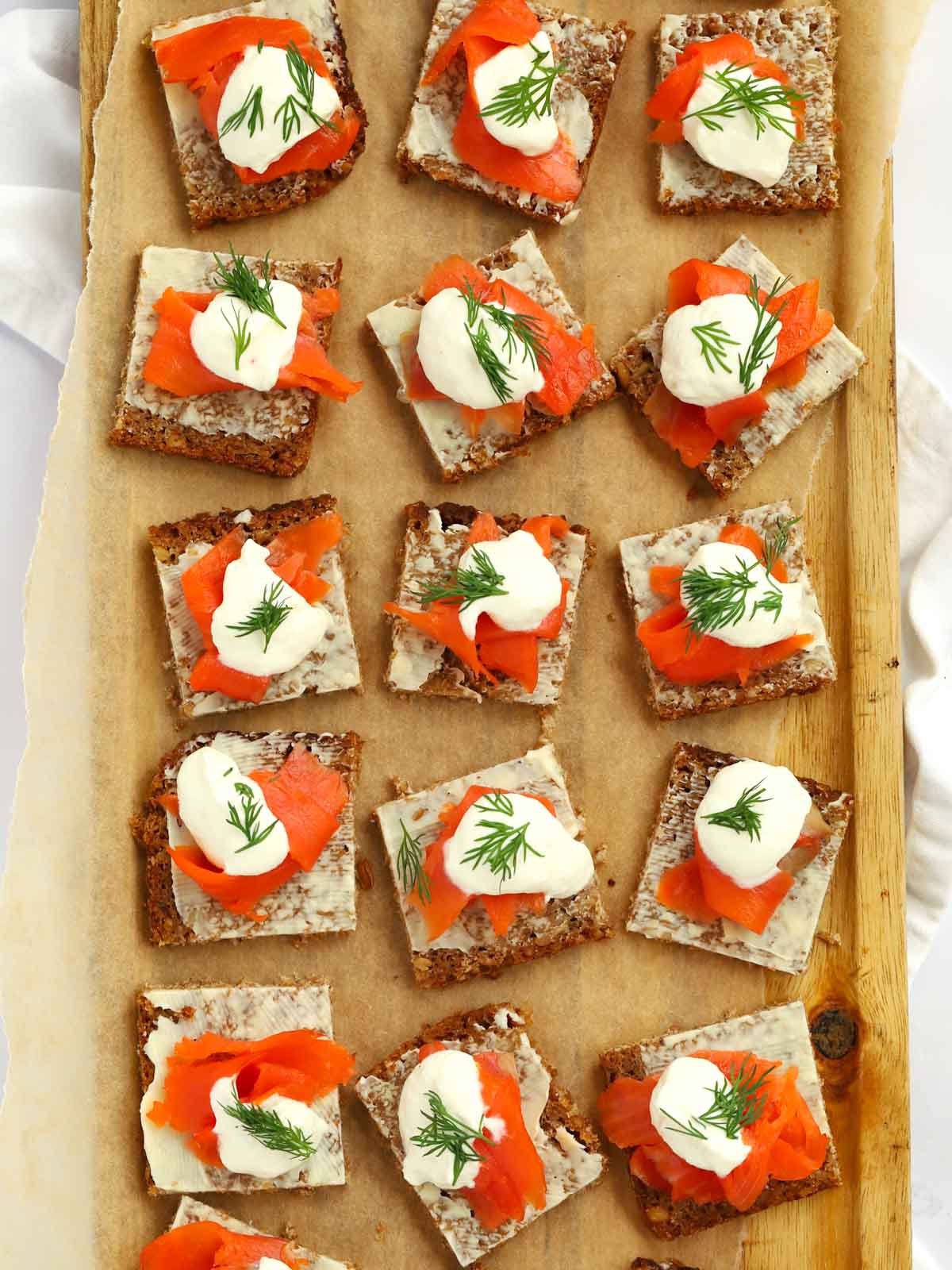Little squares of smoked salmon on rye bread for a starter or appetiser.